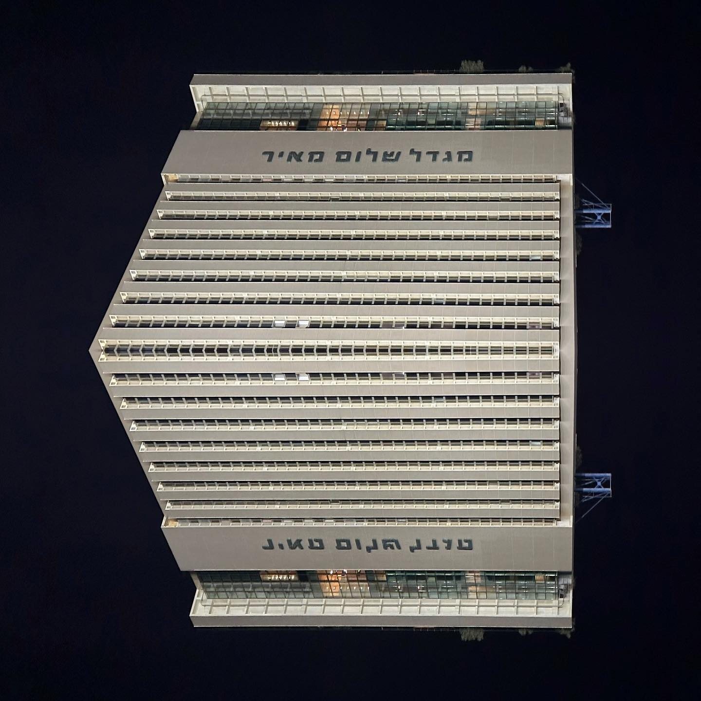 Modern high-rise building with Hebrew text